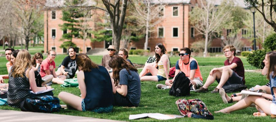 Wheaton College IL students in class sitting on the lawn outside