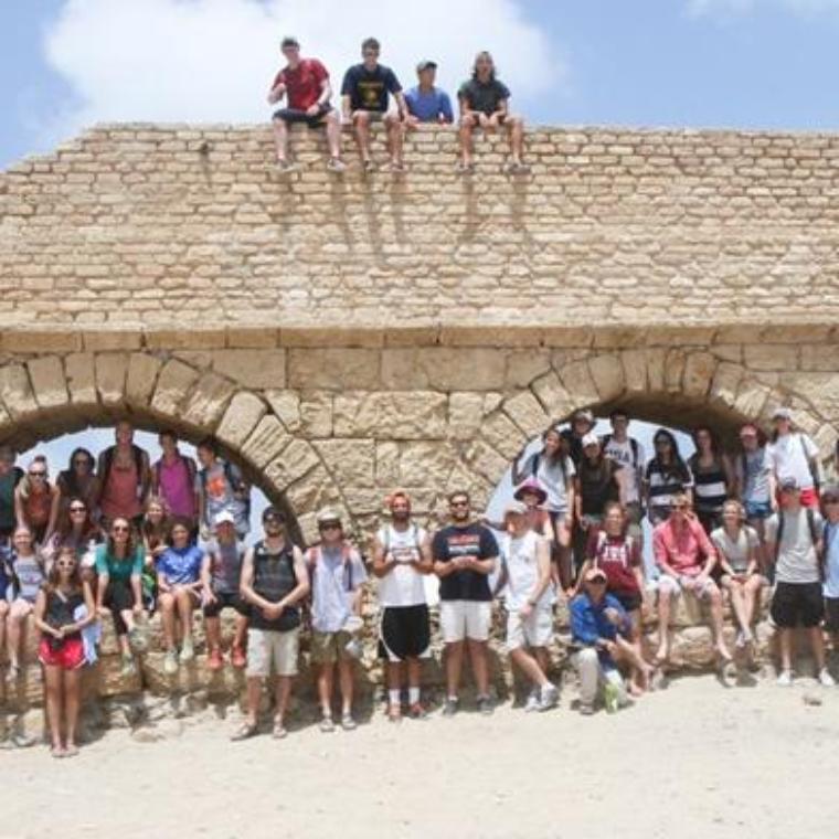 Students by a holy land structure