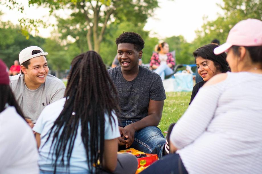 students sit in circle on lawn