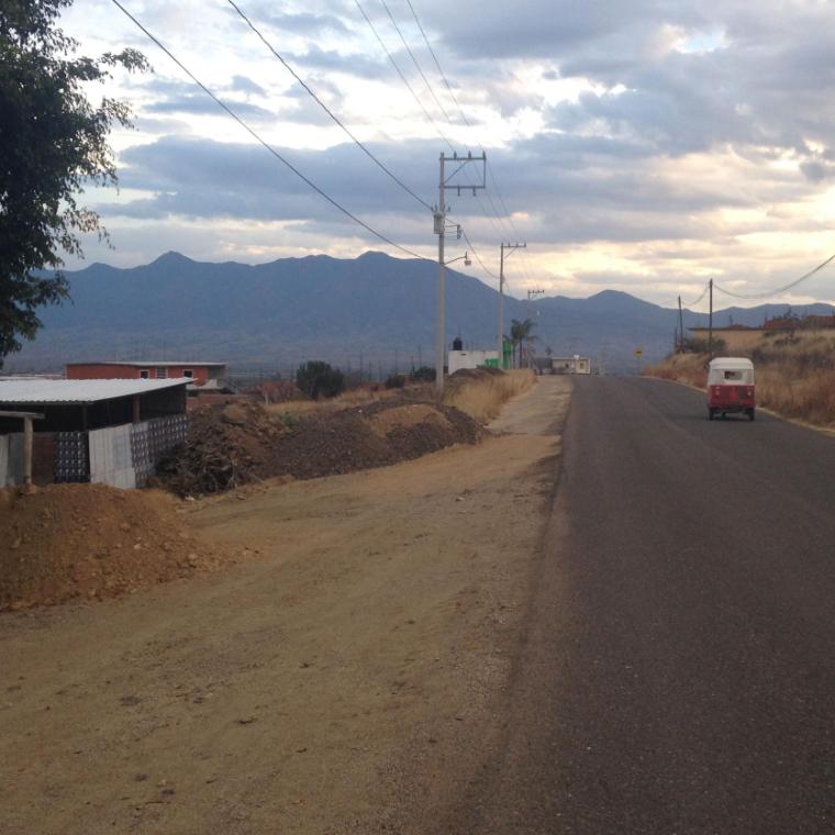 Old van on desert road with mountains in background