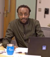 A student behind his computer smiling