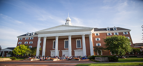 Graduate Students sitting in front of the Billy Graham Center during orientation