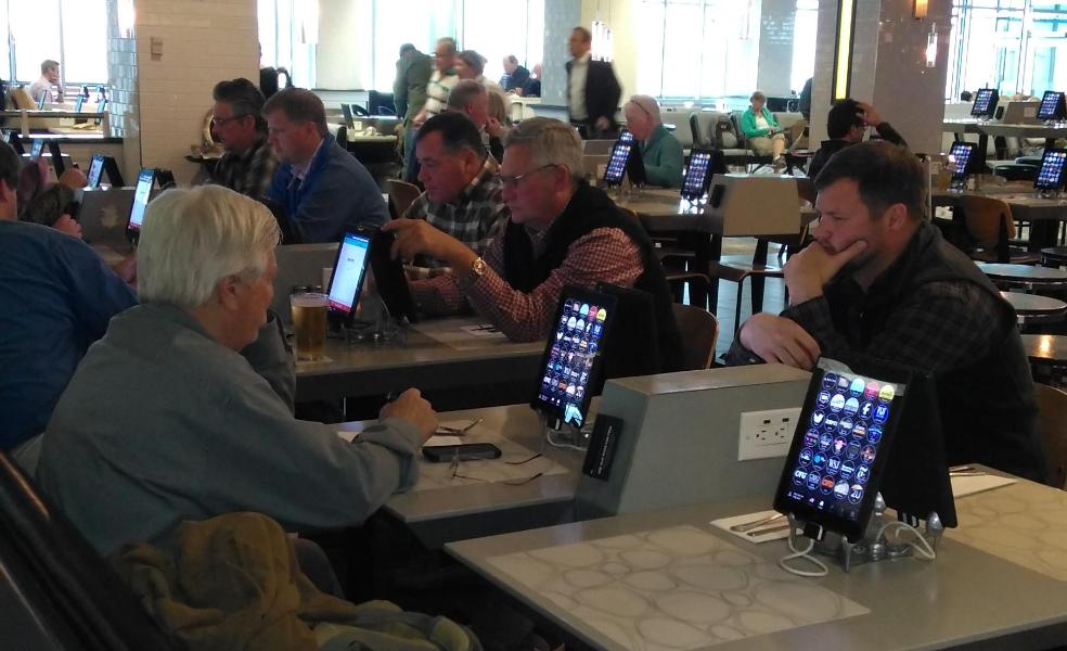 Customers at airport terminal restaurant using iPads