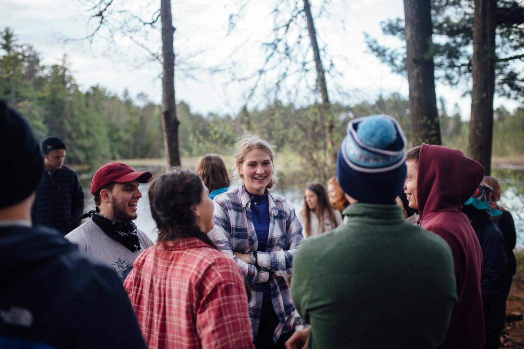 Group of friends talking outside at HoneyRock Camp in Three Lakes, WI