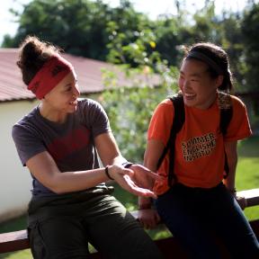 two women talking on deck, smiling