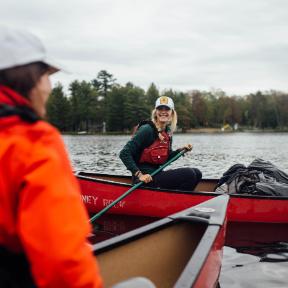 two women canoeing on Long Lake at HoneyRock in Three Lakes, WI