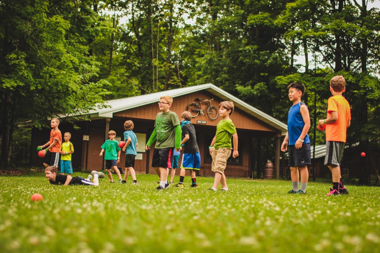 boys get ready to play dodgeball on playing field at honeyrock in three lakes, wi