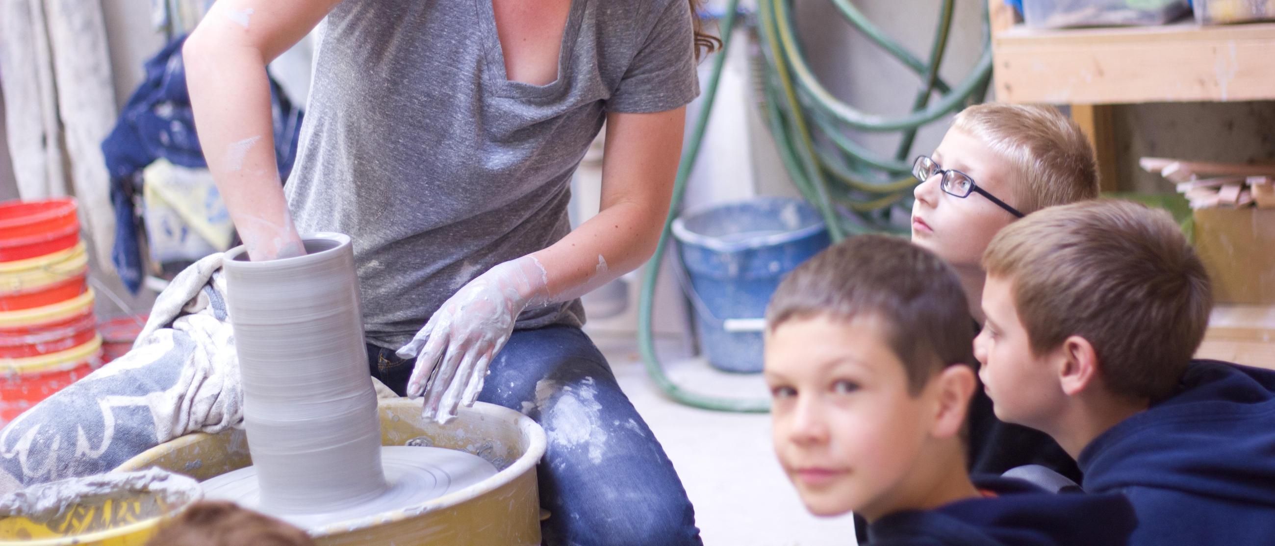 HoneyRock staff showing children pottery