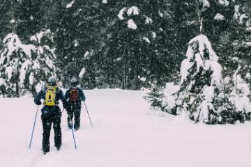 two students cross country skiing at honeyrock in three lakes, wi