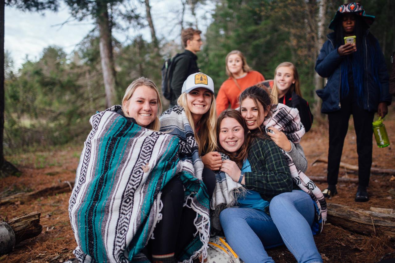 Several women sitting near campfire site at HoneyRock 