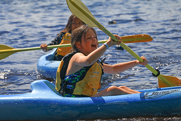 Two girls rowing on water