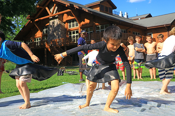 Boys playing slip-n-slide game