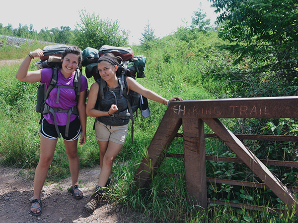 Two Students Standing at Bridge with Backpacks Early Morning